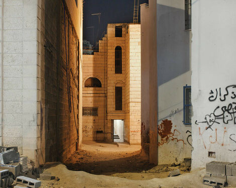 Sand-coated roads leading down an alley between two brick buildings