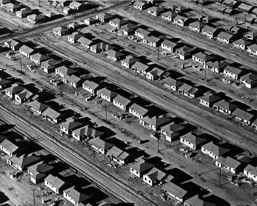 Aerial view of multiple rows of homes on dirt roads under construction