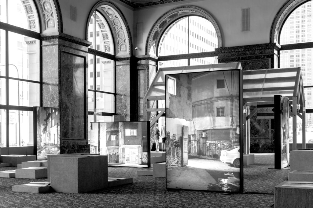 inside a room with arched, glass windows with artwork on display