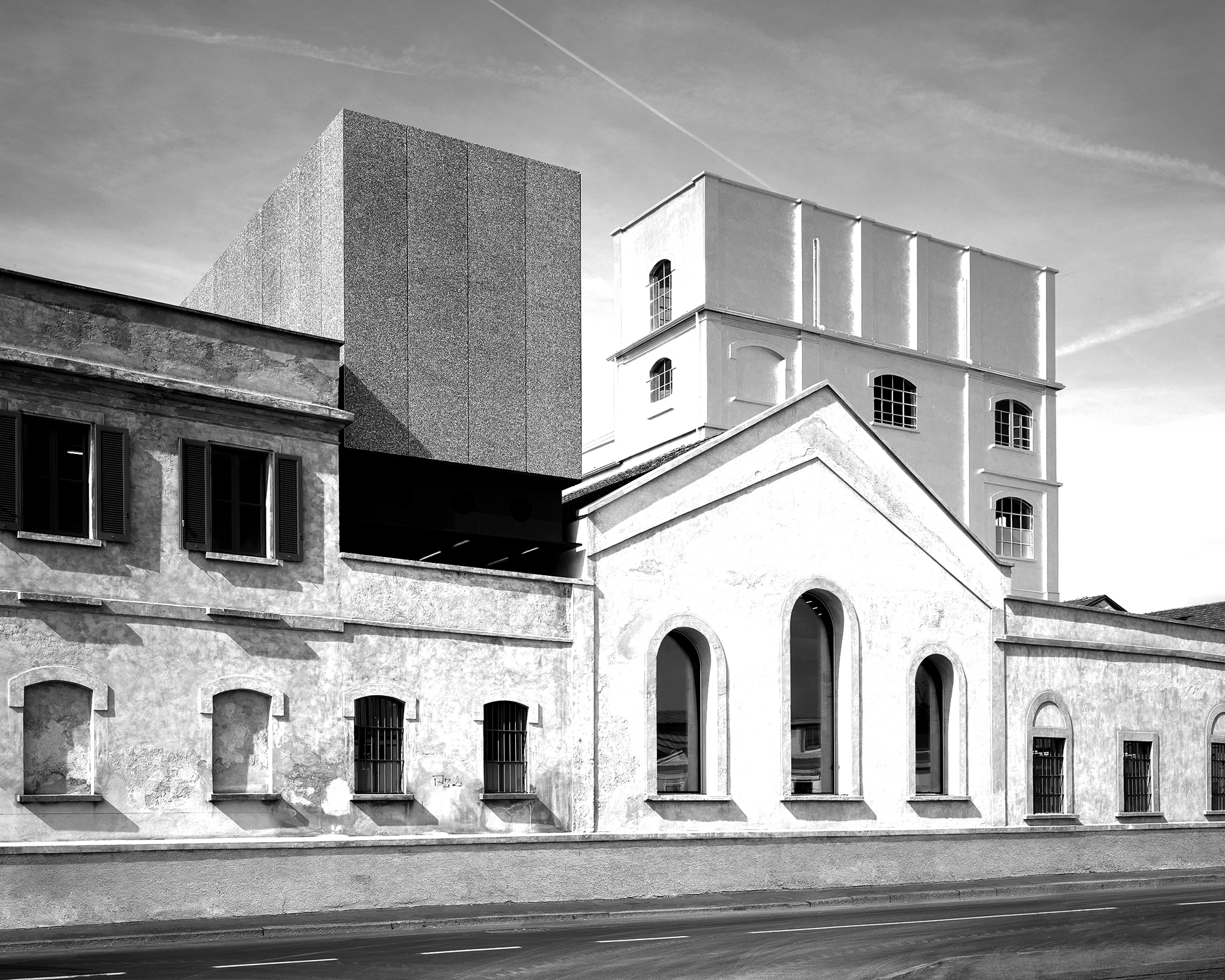 Black and white photograph of an old, three story building with a white facade