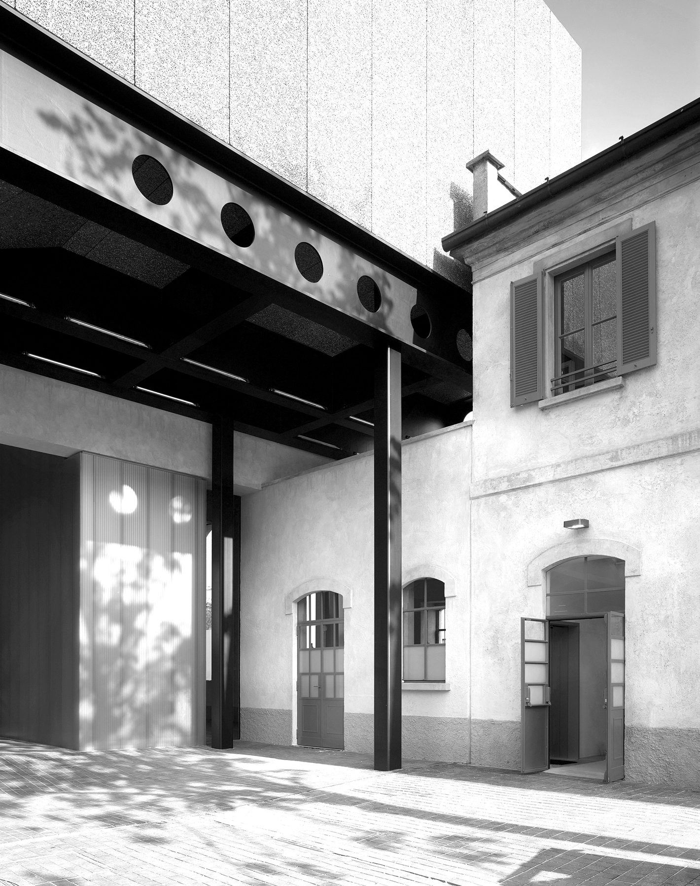 Black and white photograph of a 2 story building with portico over a doorway