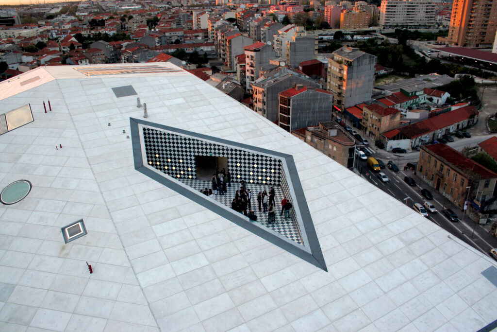 Arial view of the top of a building with a diamond shaped, recessed  outdoor space with people standing