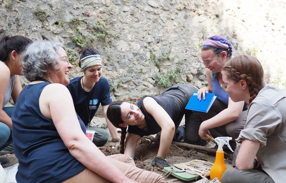 Professor and five students on an archaeological dig.