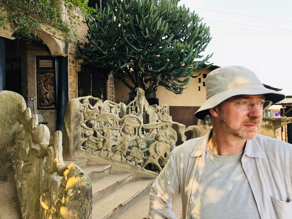 Gareth Doherty stands in front of a building that has a decorative railing adjacent to a staircase. 