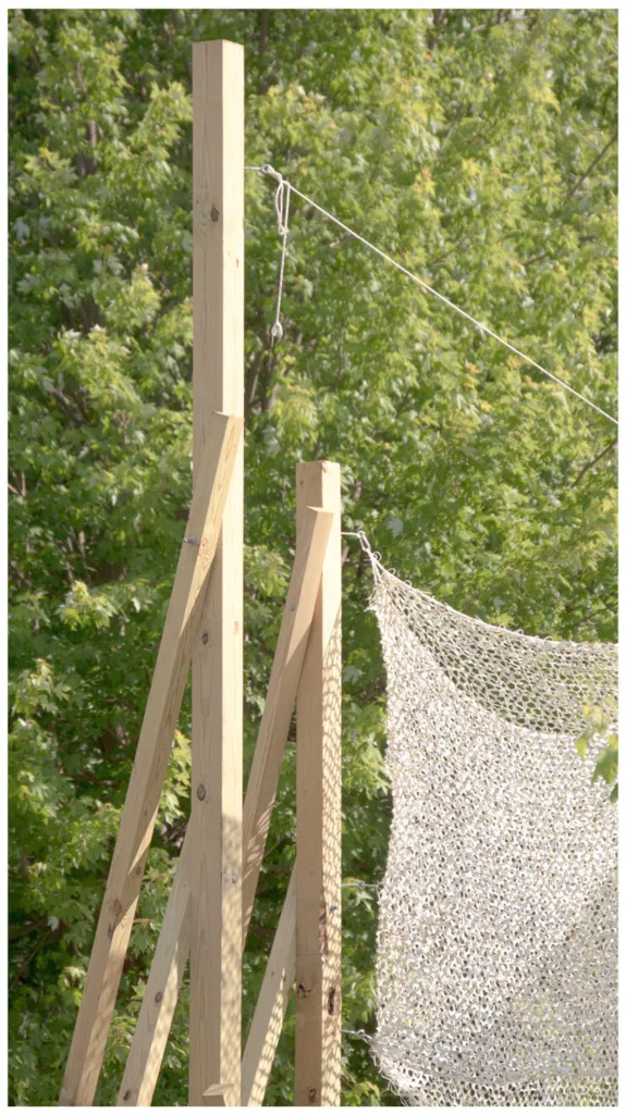 Detail of wooden posts holding mesh canopy.