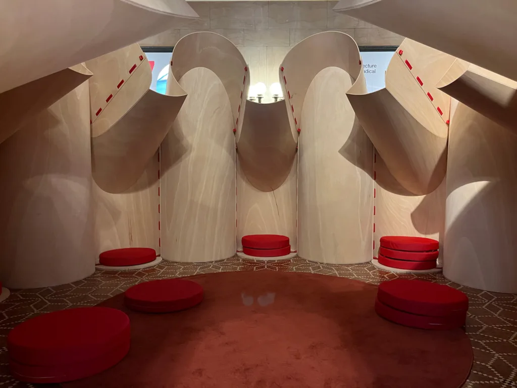 Circular plywood architecture pod with niches for sitting.