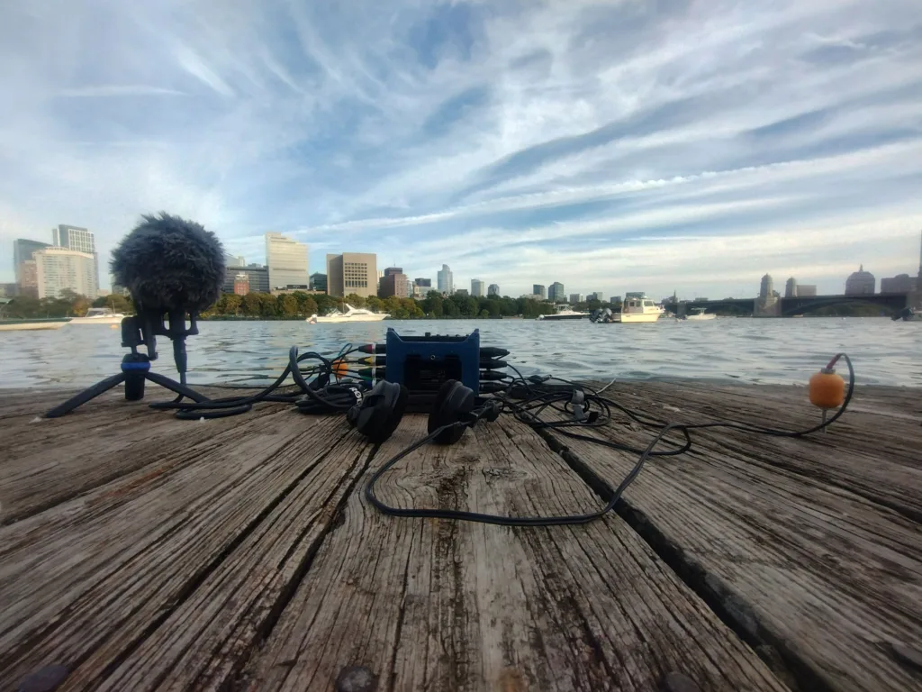 Sound recording equipment on a wooden platform facing the Charles River. 