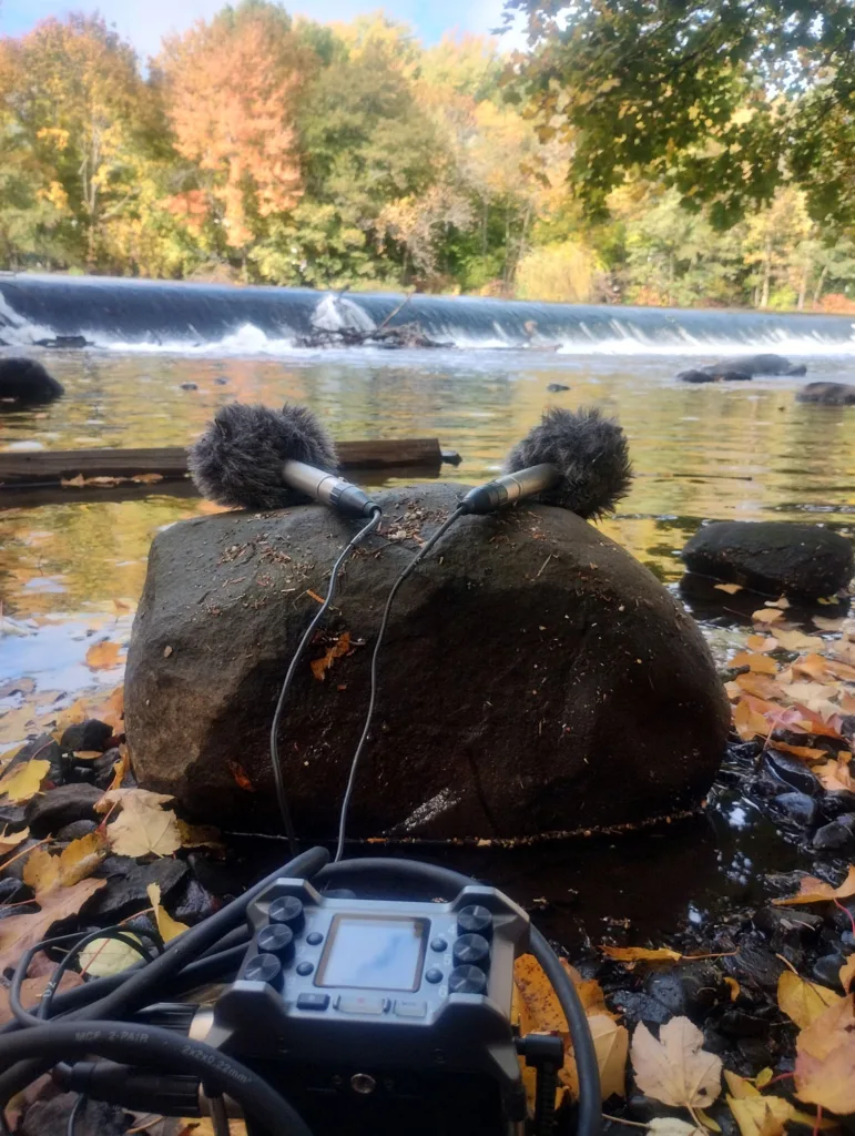 Microphones record the sound of water flowing over a low dam. 