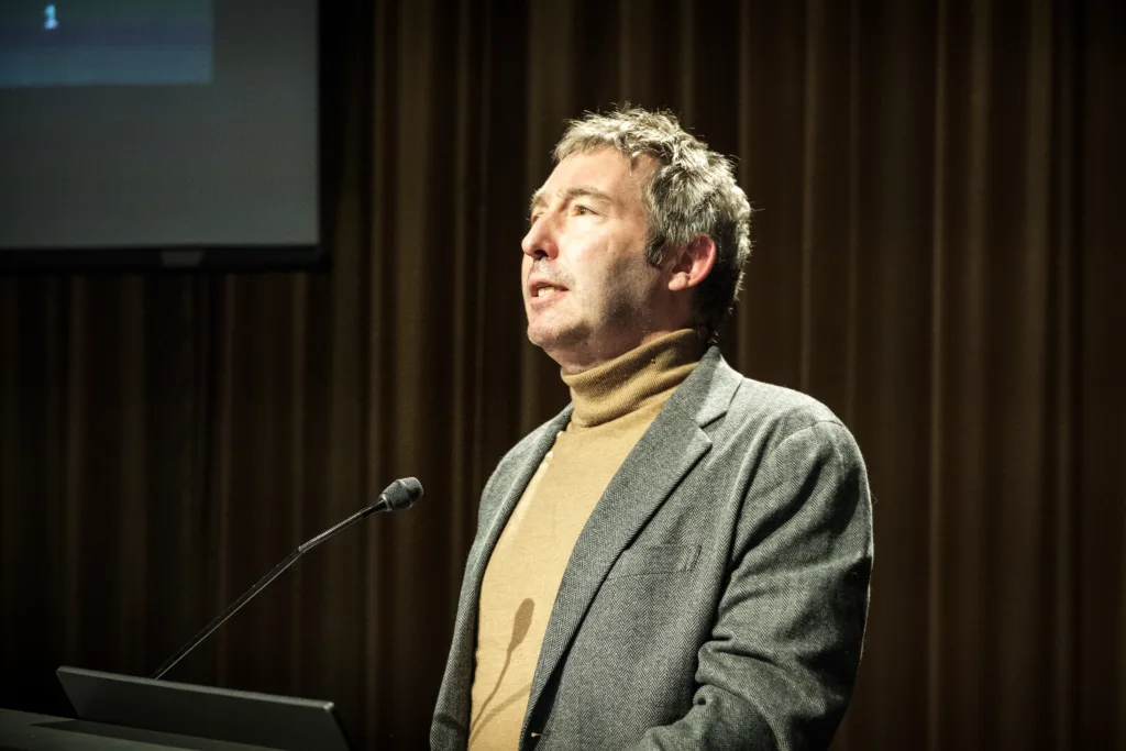 Mathias Risse speaks at a podium at the Graduate School of Design. 