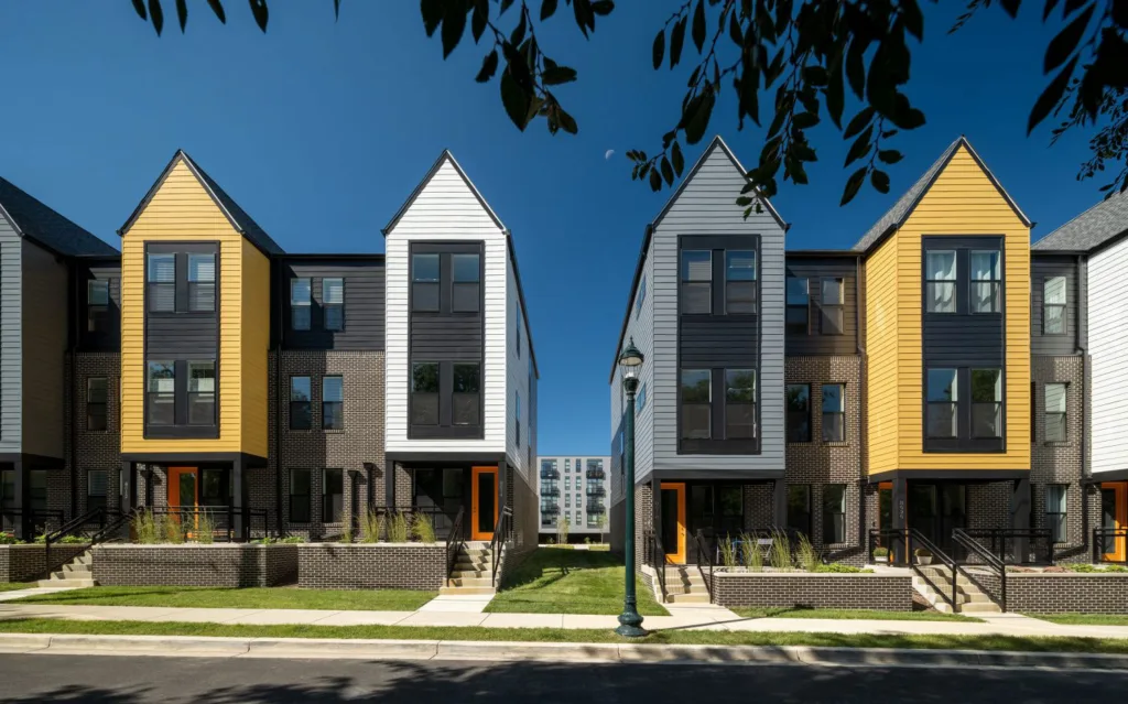 Brown brick townhouses with gray and yellow and white accents.