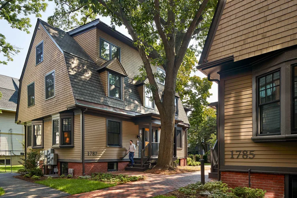 Two shingle-style houses, tan in color.
