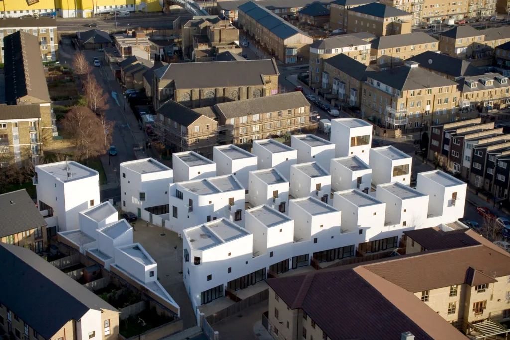 Aerial view of white, Mediterranean-looking housing development in the midst of a largely brick and stone neighborhood.