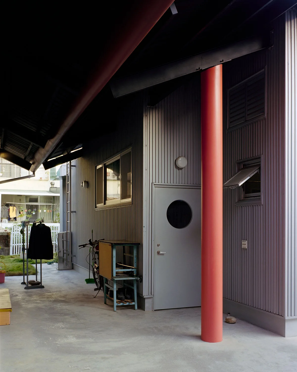 An entryway to a house with corrugated metal walls. 