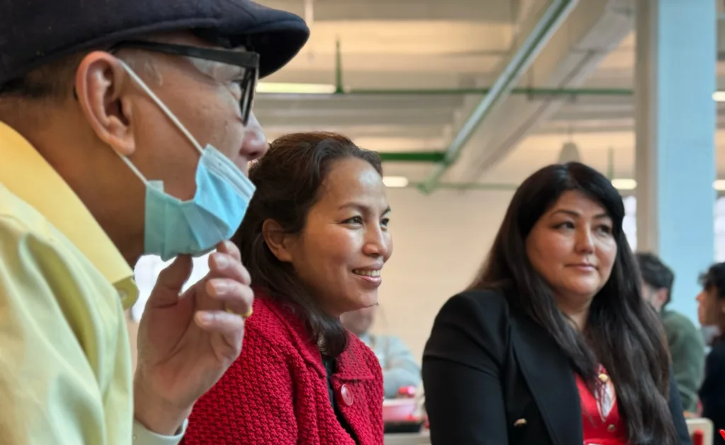 Three people--one man and two women--talking.