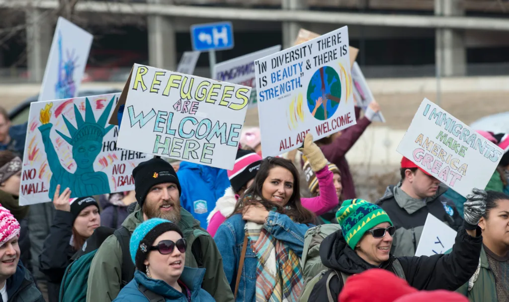 People with pro-refugee signs at a rally.