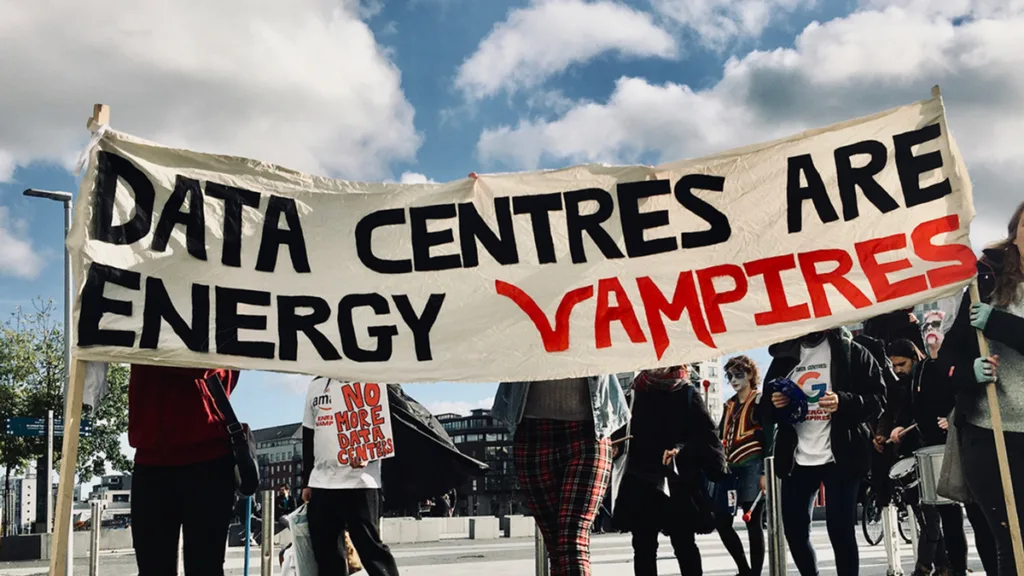 A group of protestors hold a banner reading Data Centres are Energy Vampires.