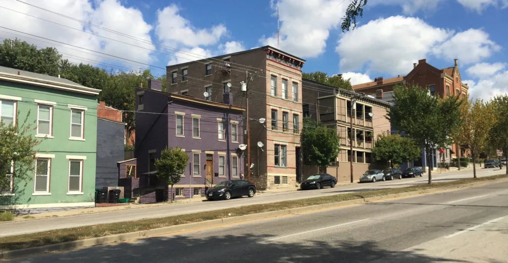 Low-rise houses line a sloped city street.