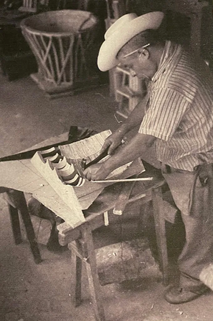 Historic image of a man crafting a wood mold. 
