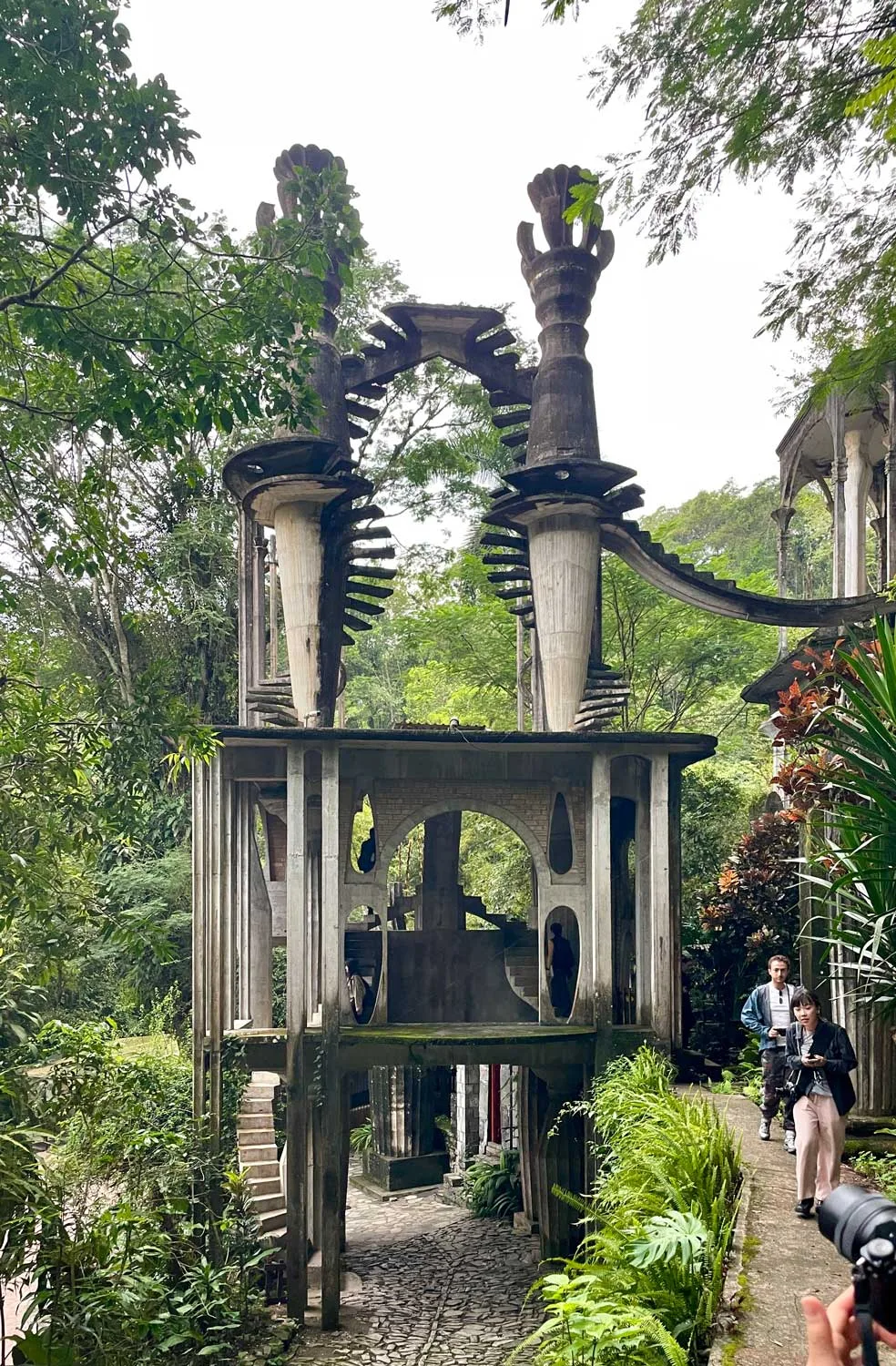 A multi-story concrete folly rising amid jungle vegetation.